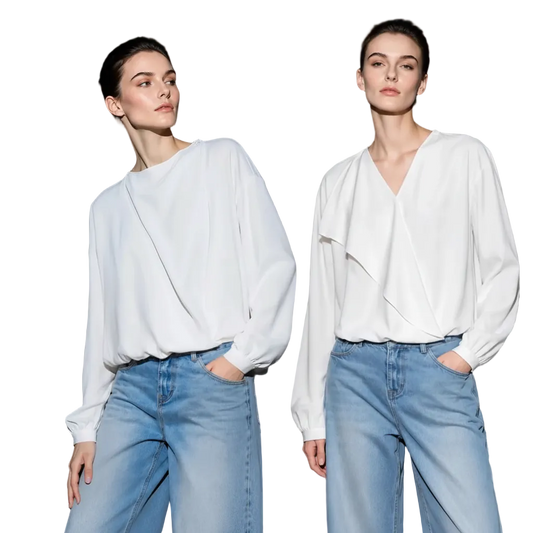 Two female models wearing white AMII long-sleeve wrap-style blouse tops and light blue jeans, posed against a dark studio background. The AMII brand name appears at top left, and a callout box on the left highlights soft, touch-sensitive fabric.