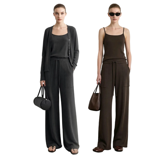 Two models wearing AMII wide-leg pants and matching tops in dark gray and dark brown, standing against a light gray wall. The left model wears a dark gray cardigan over a black tank top, and the right model wears a dark brown camisole with matching brown pants.