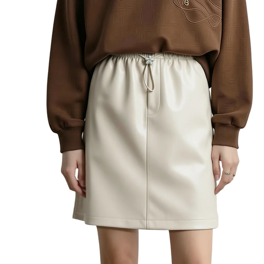 A model wearing a cream-colored faux leather mini skirt with an elastic drawstring waist and a brown sweatshirt. The image includes Chinese text overlays on the left side describing the product features.