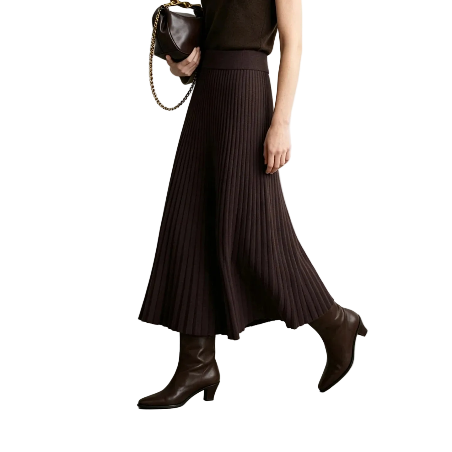 A model wearing a dark brown pleated knit midi skirt, paired with matching dark brown ankle boots and holding a brown handbag, set against a minimalist studio background with the AMII brand logo in the top left corner.