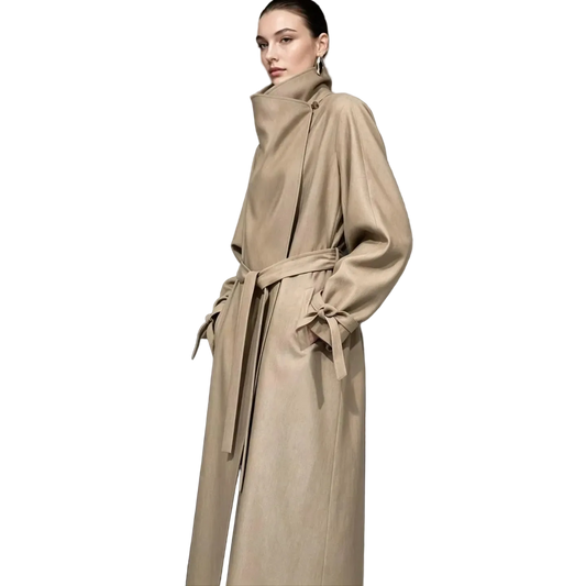 A model wears a long beige AMII coat with a high draped collar, long sleeves, and a matching waist tie. The background is a dark studio setting with a textured panel, and a small inset on the left shows a fabric texture closeup labeled 'Acetate texture pearlescent weave'.