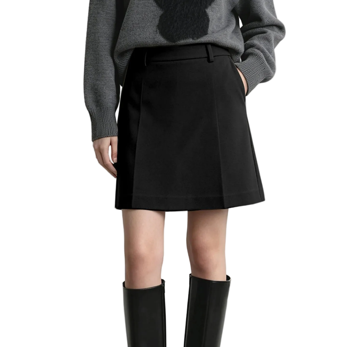 A model wearing a black A-line mini skirt with side pockets, paired with a gray knit sweater and black knee-high boots, shown from the chest down against a light gray studio background.