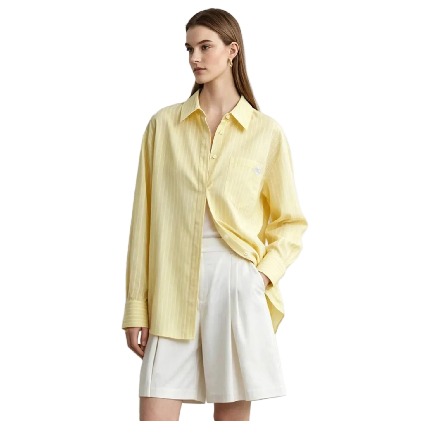 A woman modeling a pale yellow long-sleeve button-up shirt with subtle vertical stripes, worn open over a white top and white shorts. The AMII brand logo is visible in the top left corner against a light gray studio background.
