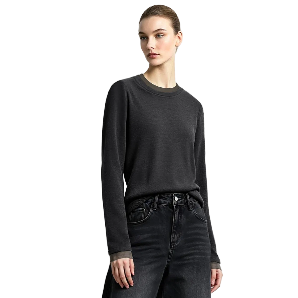 A woman modeling a dark charcoal gray long-sleeve crewneck sweater, paired with dark gray jeans, against a light gray studio background with the AMII brand logo in the top left corner.